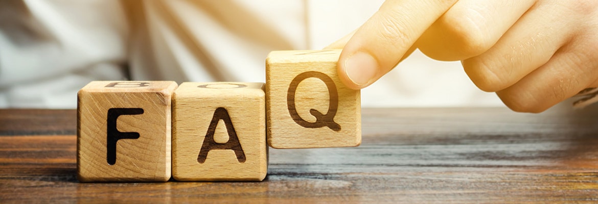 Person placing three blocks that spell "FAQ" on a table