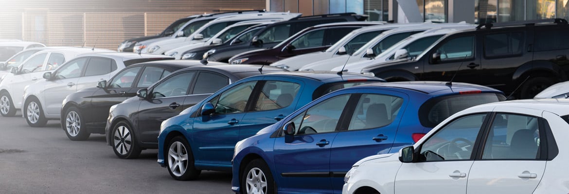 Rows of cars parked in a dealership lot.