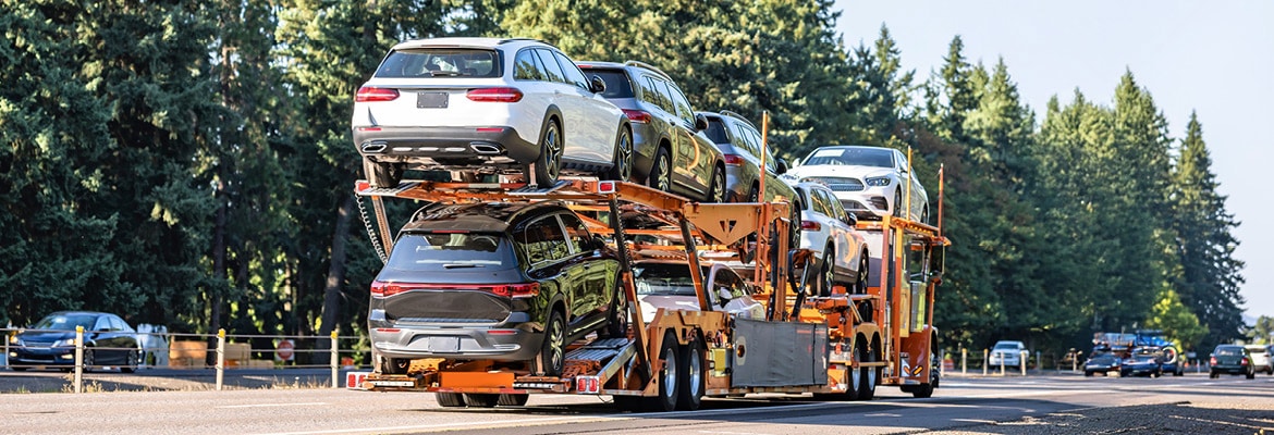 Open car carrier loaded with multiple vehicles.