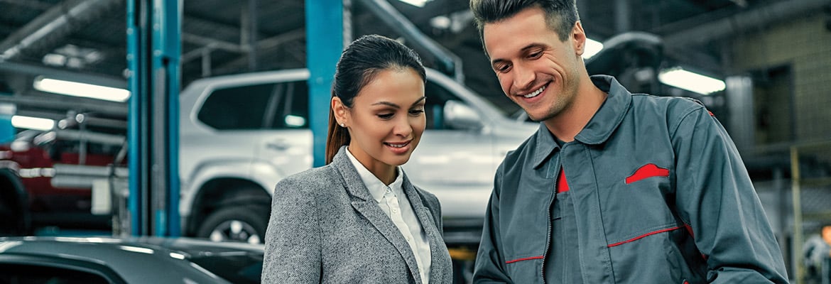 Auto repair technician talking to a customer.