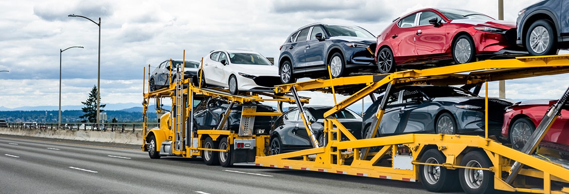 Yellow car hauler shipping vehicles on the highway.