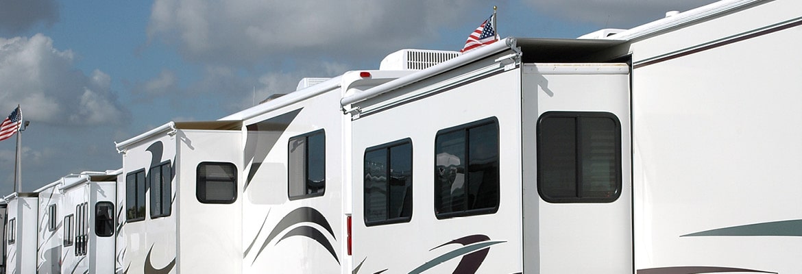 Several RVs parked in a row outside.