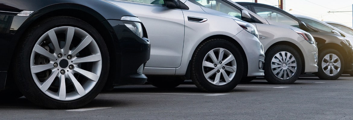 Close up picture of multiple cars parked in a row