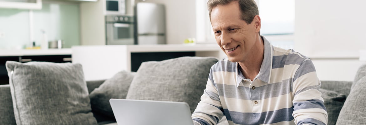 A man on a couch working on his laptop