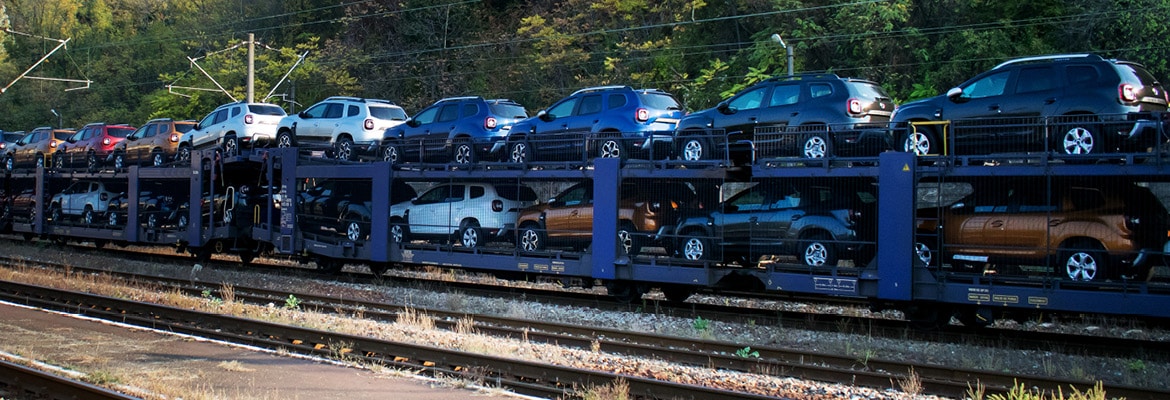 Vehicles being transported on train car.