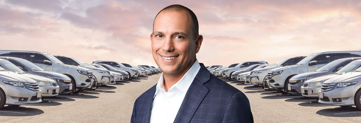 Headshot of Mike Trudeau from Montway with a backdrop of cars lined up
