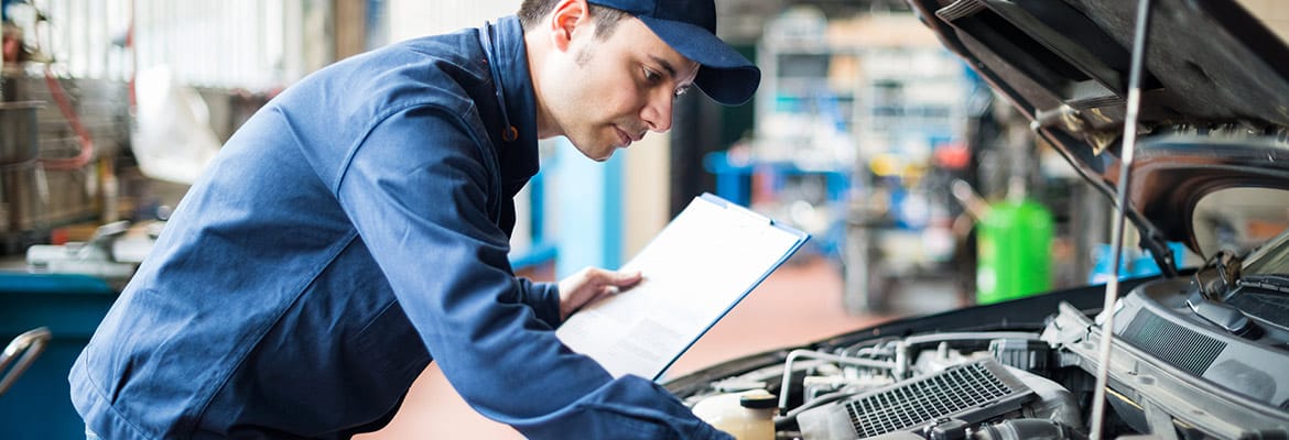 Professional performing pre-purchase inspection for used car buyer.
