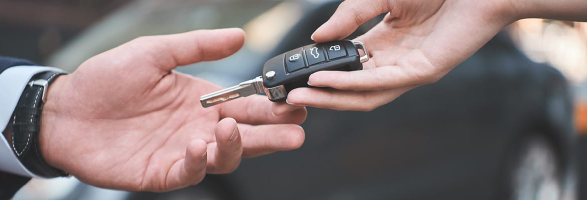 Hands exchanging keys of rental car.