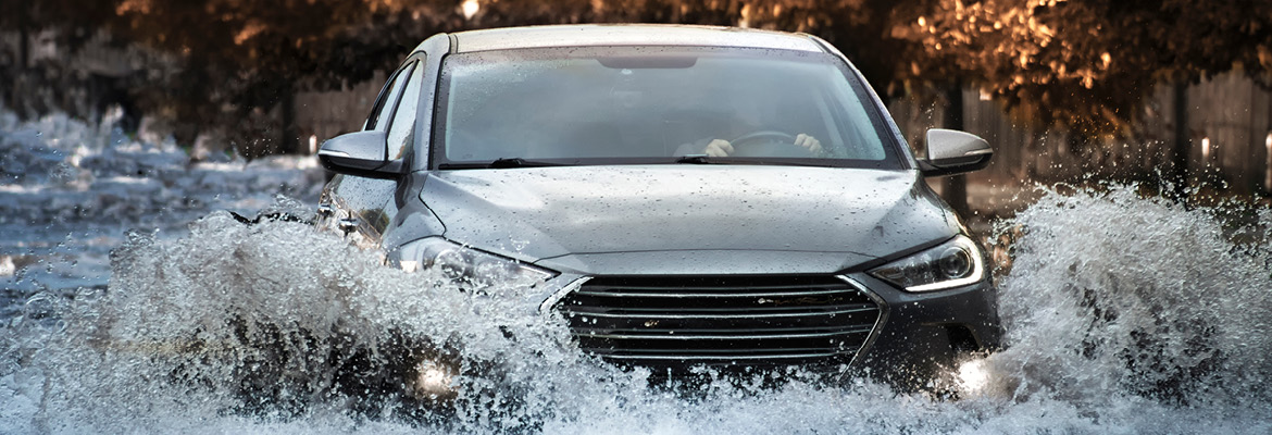 Used car driving through flooded street.