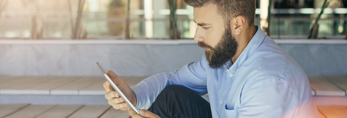A man selling his car on CarGurus website from a tablet.