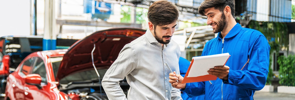 Customer meeting with dealership service advisor to discuss car maintenance and repairs.