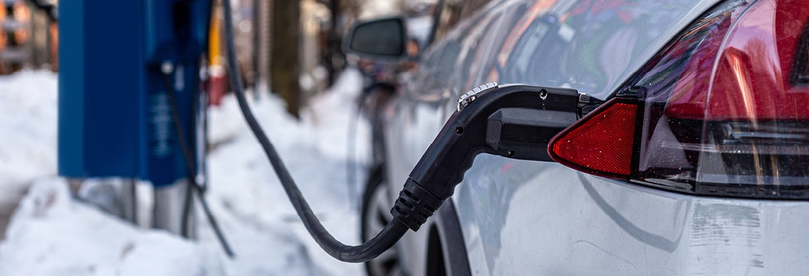 An electric vehicle charging in winter weather.