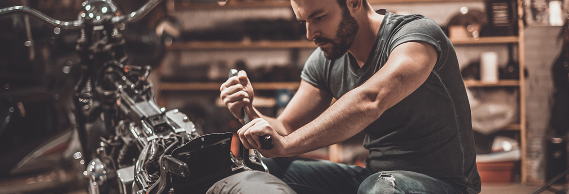 Man preparing motorcycle for auto transport.